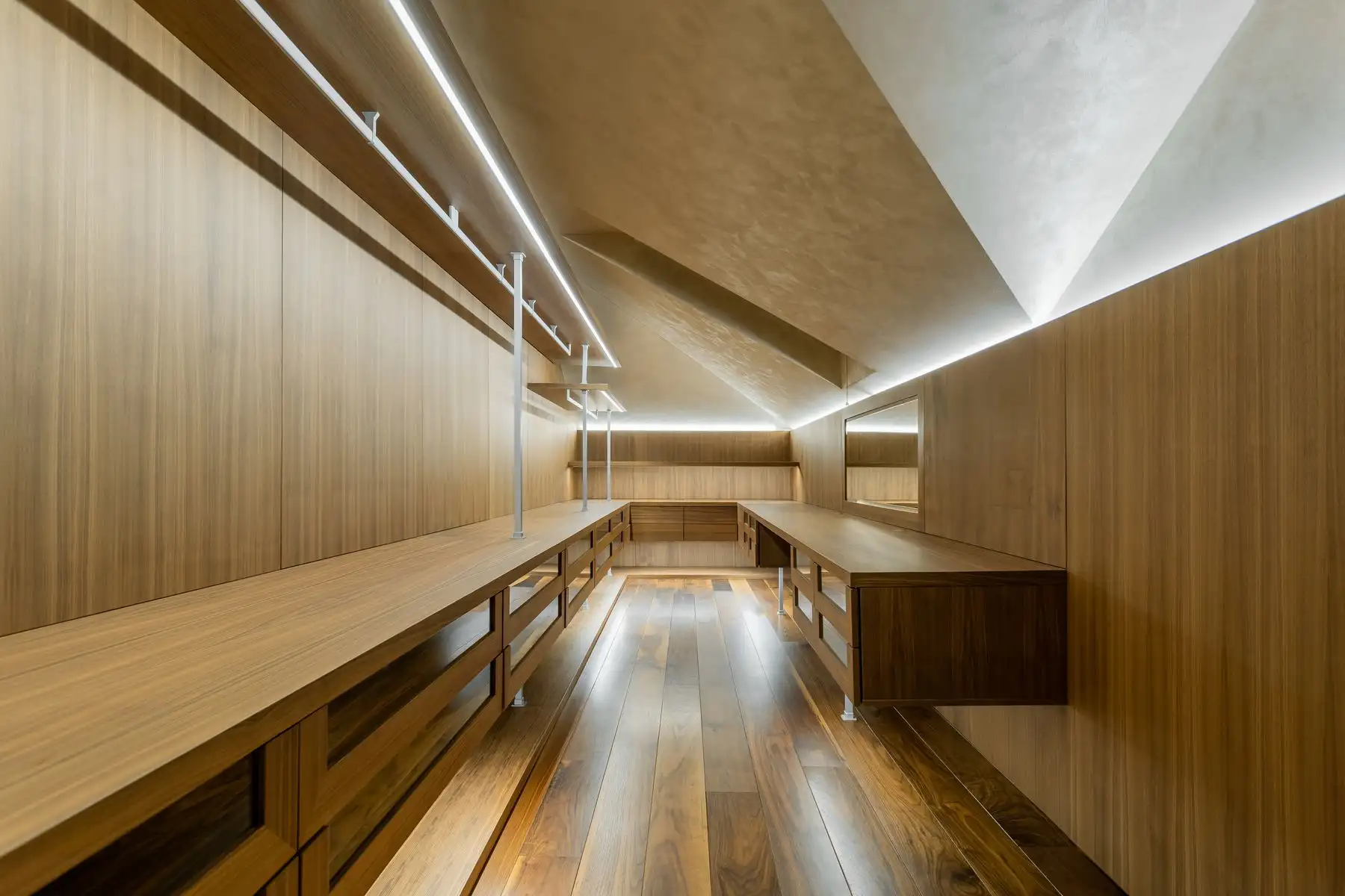 Dressing sous pente entièrement en bois, tringles éclairées et meubles bas sous les rampants